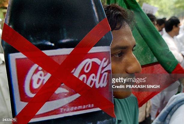 Activists of the Indian federal Democratic Party drink display placards during a demonstration against cola giant Coke in New Delhi, 21 August 2003...