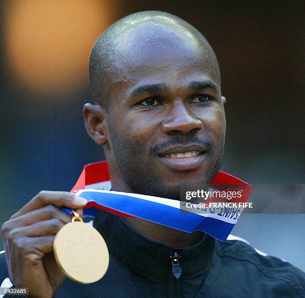 Men's 100m gold medal winner Kim Collins of Saint Kitts and Nevis poses on the podium 26 August 2003 during the 9th IAAF World Athletics...