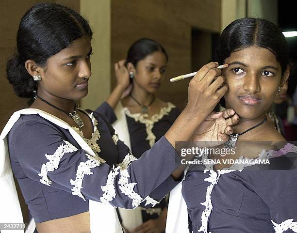 Sri Lankan girl Thiloka Nilmini applies make-up to her twin Thilini Dasanthi, in Maharagama,near Colombo, 21 August 2003. The twins are rehearsing...