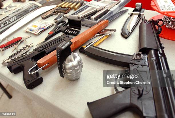 Toy guns, knives and other assorted property are displayed during a press conference at John F. Kennedy airport August 27, 2003 in New York City. The...