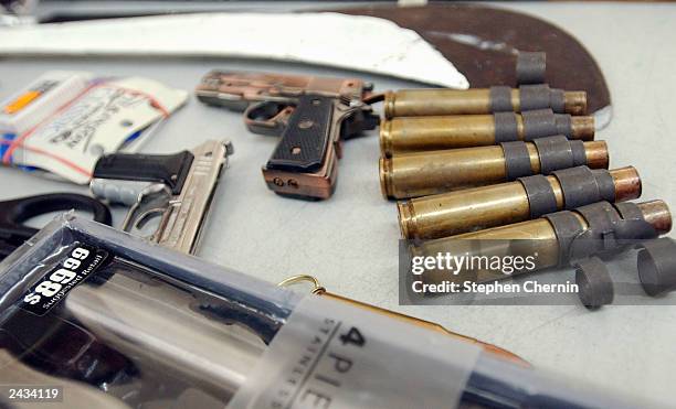Shell casings, fake revolvers, a machete and a cutlery set are displayed during a press conference at John F. Kennedy airport August 27, 2003 in New...