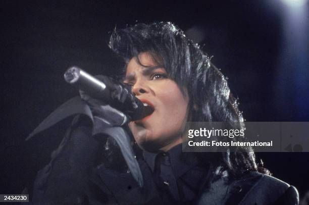 Headshot of American pop and R&B singer Janet Jackson singing on stage during a concert, circa 1991.