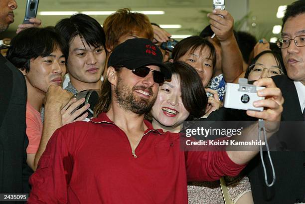 Actor Tom Cruise poses for photos with Japanese fans in the arrival lobby at Haneda Airport August 28, 2003 in Tokyo, Japan. Cruise is currently on a...