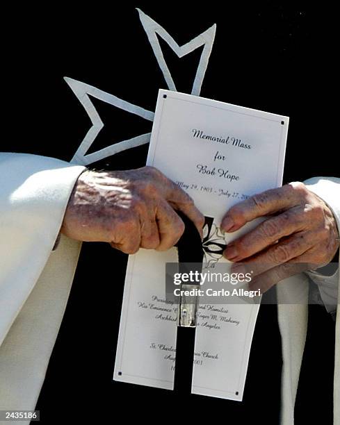 Priest holds a program as he leaves the memorial service for Bob Hope outside the St. Charles church August 27, 2003 in Los Angeles, California. The...