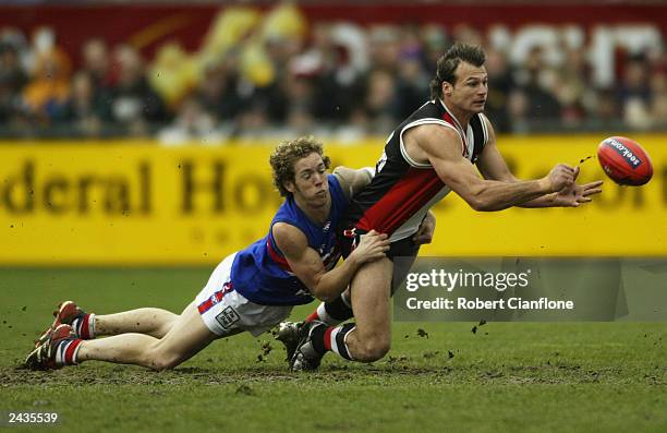 Aaron Hamill of the Saints is tackled by Robert Murphy of the Bulldogs during the round 21 AFL match between the Saint Kilda Saints and the Western...