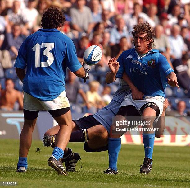 Italy's Mauro Bergamasco passes to Andrea Masi as he is tackled by Scotland's Jason White during their World Cup warm up match at Murrayfield Stadium...