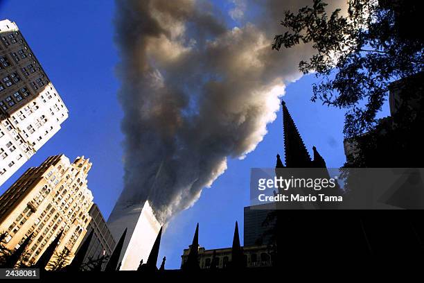Smoke spews from a tower of the World Trade Center September 11, 2001 after two hijacked airplanes hit the twin towers in a terrorist attack on New...
