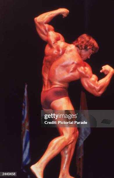 Austrian-born bodybuilder Arnold Schwarzenegger flexes his muscles onstage, 1970s.