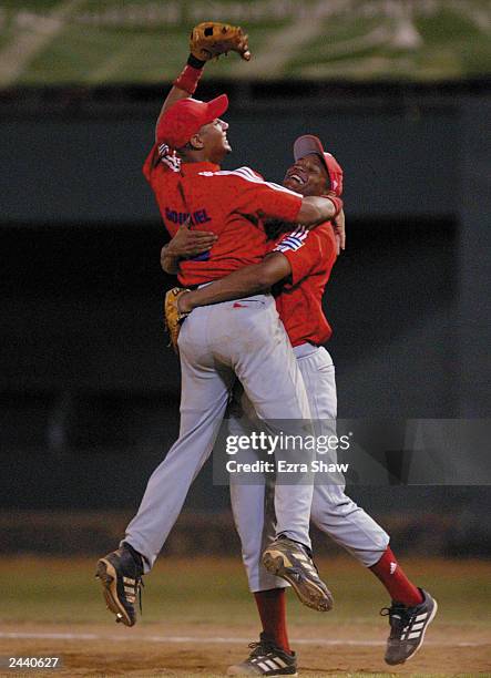 Winning pitcher Norge Luis Vera hugs Yulieski Gourriel of Cuba after they beat the USA during Men's Baseball at Quisqueya Stadium on August 12, 2003...