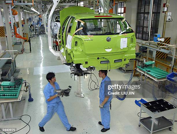 Chinese workers assemble a German auto giant Volkswagen's Polo car at a production line in its plant in Shanghai, 09 June 2003. Volkswagen AG has...