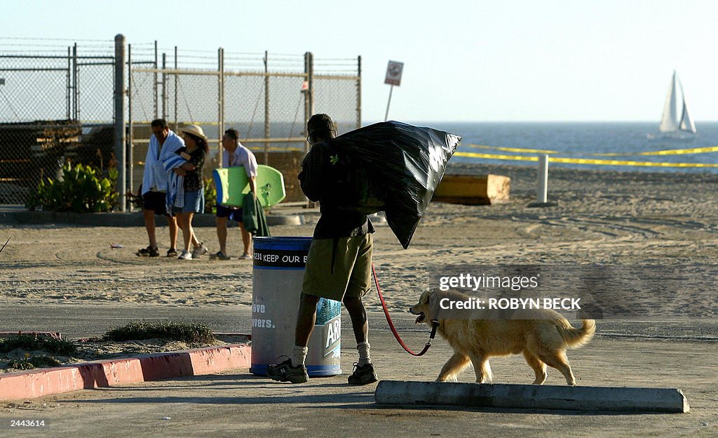 A homeless man (front) with his dog stop