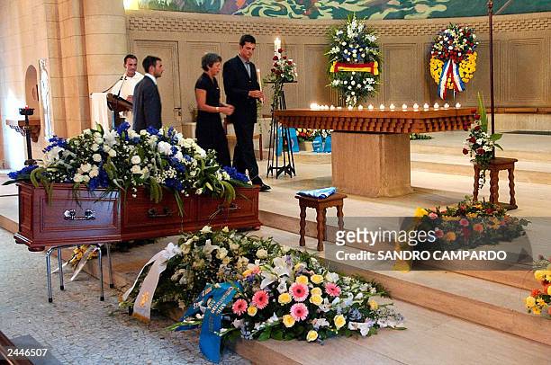 Laurent and Adrian de Mello , sons of Sergio Vieira de Mello, and his wife Annie light a candel near the coffin containing the body of Brazilian...