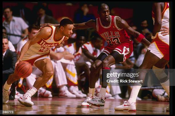 Guard Doc Rivers of the Atlanta Hawks tries to fend off guard Michael Jordan of the Chicago Bulls during a game at the Omni in Atlanta, Georgia.