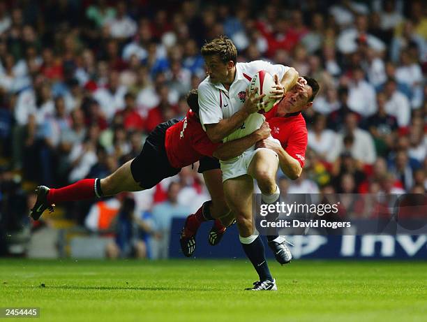 Dan Luger of England is tackled by Mark Jones and Mark Taylor of Wales during the Rugby Union International match between Wales and England on August...