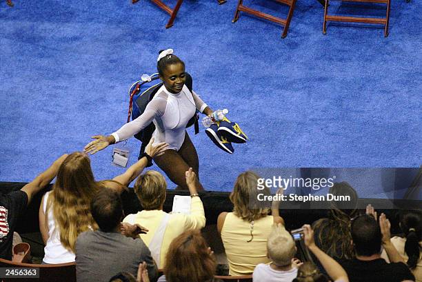 Daiane Dos Santos of Brazil celebrates with fans after winning the gold medal in the women's floor exercise during the Apparatus Finals of the 2003...