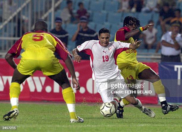 Tunisia's Anis Ayari fights for the ball with Guinea's Dane Bobo and Ibraima Soriconte duringg their friendly match at the Rades stadium in Tunis 20...