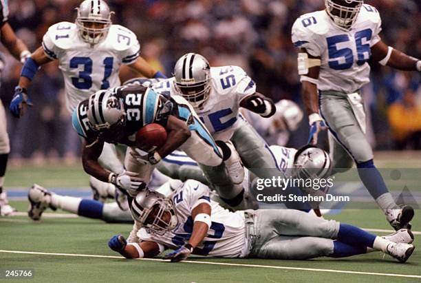 Running back Fred Lane of the Carolina Panthers is tackled by linebacker Fred Strickland of the Dallas Cowboys during a game at Texas Stadium in...