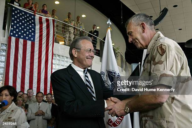 Retiring Commander of CENTCOM Gen. Tommy Franks shakes hands with Secretary of Defense Donald Rumsfeld July 7, 2003 during his change-of-command...