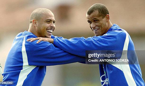 Brazilian soccer star Ronaldo Nazario , of spanish team Real Madrid and teammate Rivaldo of italian team Milan, smiles while stretch, 04 September...