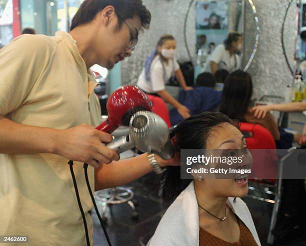 Lucy Hao a jewellery trader, gets excited by her hairdresser?s suggestion for a new haircut September 4, 2003 in Beijing, China. Hao is keeping...