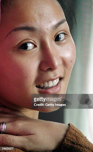Lucy Hao a jewellery trader, shows her face, which she recently had altered by cosmetic surgery, as she visits a cafe September 4, 2003 in Beijing,...