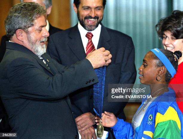 President of Brazil Luis Inacio Lula da Silva looks at the Gold medal of gymnast Daiane dos Santos , won last August at the World Gymnastic...