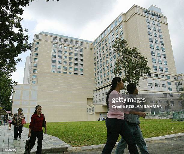 People walk past the Raffles Hospital where the Iranian twin sisters Laden and Laleh Bijani undergoing separation operation in Singapore 07 July...