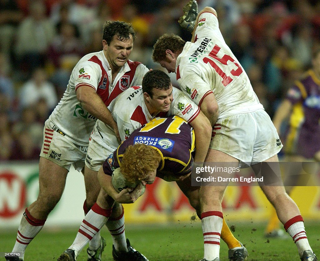 Brad Meyers of the Broncos is tackled by the Dragons defence