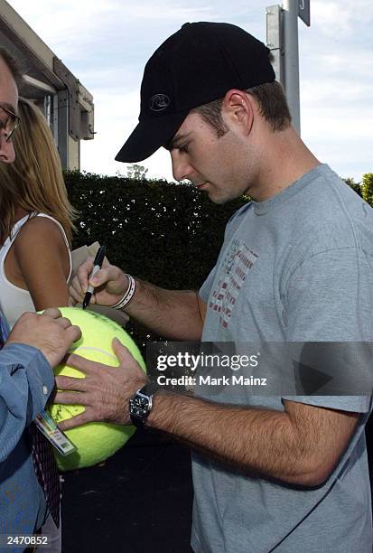 Nascar driver Jeff Gordon autographs a huge tennis ball as he attends the "Official US Open Men's Singles Finals VIP Party" at the USTA National...