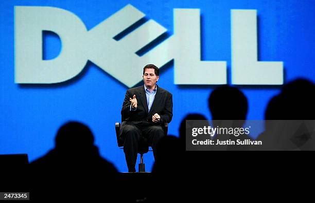 Dell CEO Michael Dell, suffering from a broken ankle, delivers a keynote address while sitting in a chair at the 2003 Oracle World Conference...
