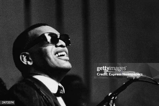 Musician Ray Charles performing at a microphone, c. 1960.