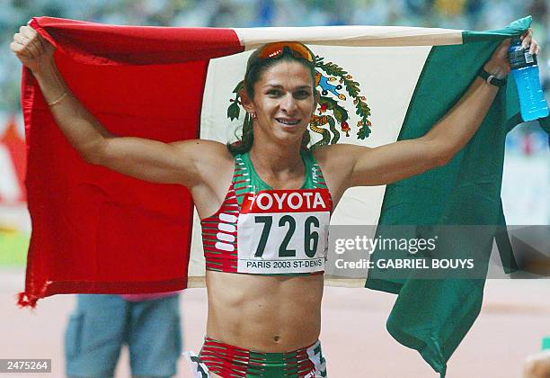 Ana Guevara of Mexico holds up her national flag after winning gold in the women's 400m final 27 August 2003, during the 9th IAAF World Athletics...