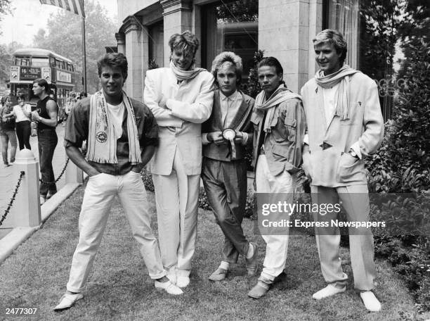 British pop group Duran Duran smile and laugh while posing on a lawn, England, c. 1983. L-R: Brothers Roger and John Taylor, Nick Rhodes, Andy Taylor...