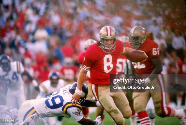Quarterback Steve Young of the San Francisco 49ers tries to break a tackle during a game against the Minnesota Vikings at Candlestick Park in San...