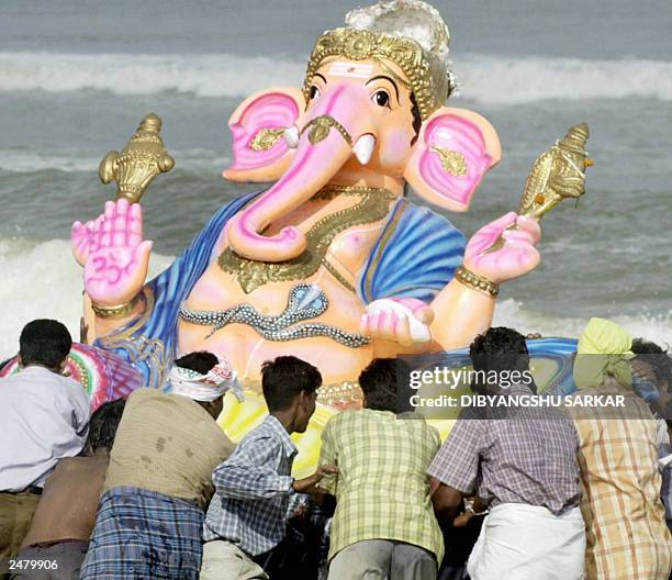 Group of unidentified Indian Hindus push an idol of the Hindu god Lord Ganesh into the sea in Madras, 07 September 2003, an act which signifies the...