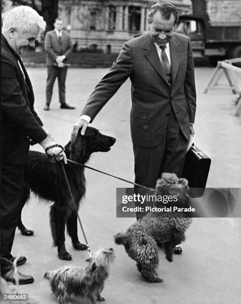 President Richard M. Nixon smiles and pets his dogs Irish Setter 'King Timahoe,' Yorkshire Terrier 'Pasha' and French Poodle 'Vicky,' outside the...