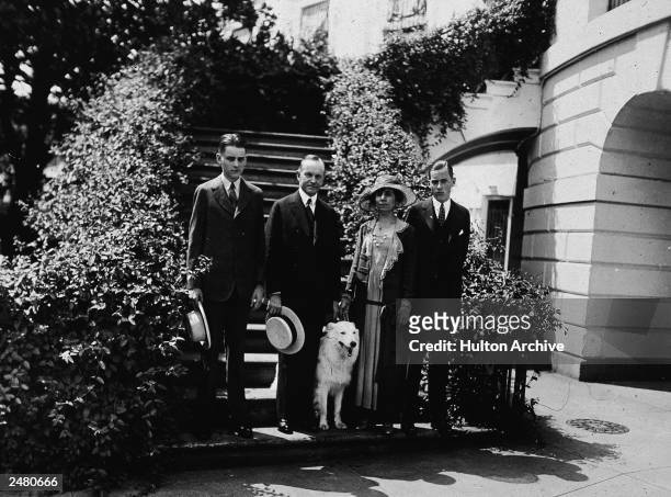 President Calvin Coolidge stands outdoors with his wife Grace, their two sons and their pet white collie 'Rob Roy, ' 1920s.