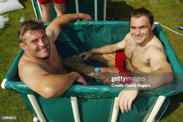 Jason Leonard and Trevor Woodman of England relax in an ice bath during England Rugby Union training held on August 6, 2003 at the Pennyhill Park...