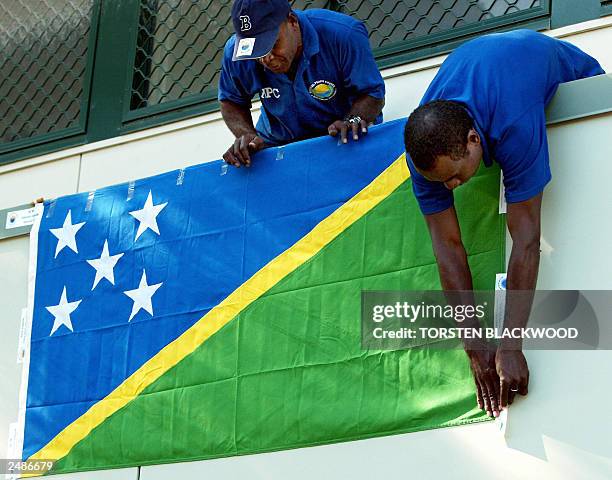 National Peace Council workers display the Solomon Islands national flag outside their office in Honiara, 26 July 2003, before destroying illegal...