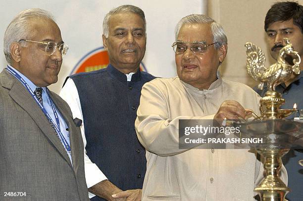 Indian Prime Minister Atal Behari Vajpayee lights a lamp while Minister of External Affairs Yashwant Sinha and Federation of Indian Chambers of...