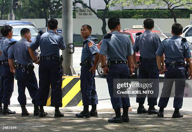 Philippine police patrol the area near the Oakwood condominium, 02 August 2003 in the financial district of Makati as part of heightened security...