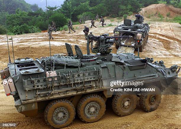 Soldiers run out form Stryker infantry carrier vehicles during a drill in Yeoncheon near the demilitarized zone, 04 August 2003. A Stryker platoon of...