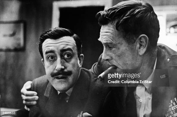 American actor Sterling Hayden , as General Jack Ripper, holds a cigar in his mouth and puts his arm around English born actor Peter Sellers , as...