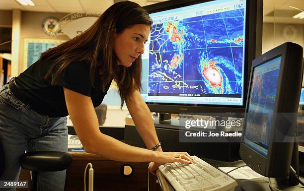 Michelle Mainelli, a meteorologist looks at a computer monitor tracking hurricane Isabel at the National Hurricane Center September 12, 2003 in...