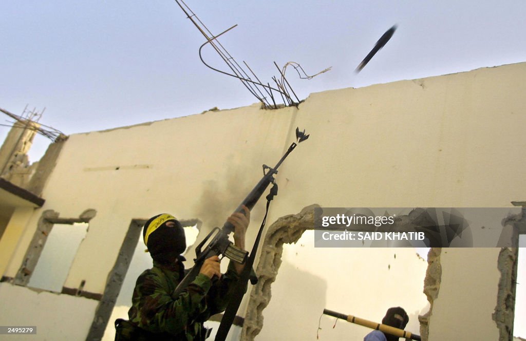 A masked Palestinian militant fires a ho