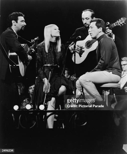 American singers Peter Yarrow, Mary Travers, and Paul Stookey of the folk music trio Peter, Paul, and Mary, perform in a television appearance with...