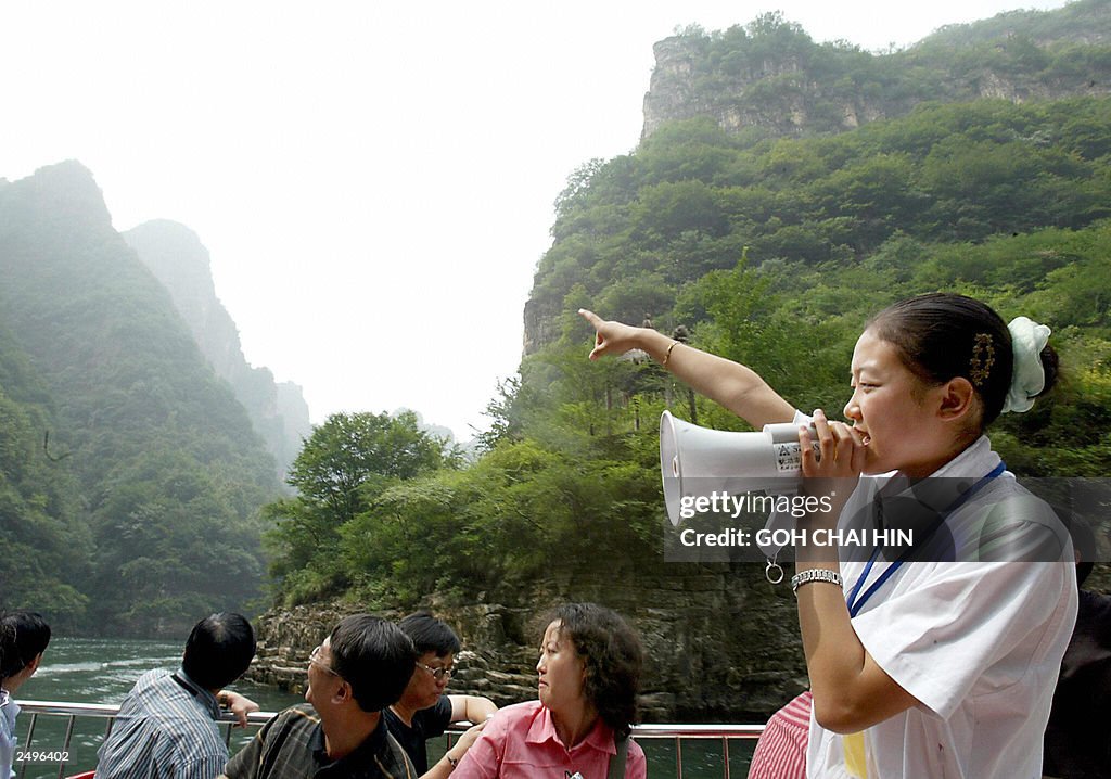 A tour guide points to scenic spot on a