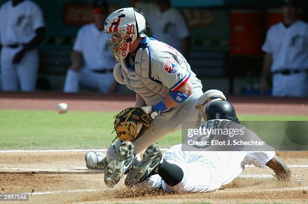 Center Fielder Juan Pierre of the Florida Marlins scores on a sacrifice fly RBI by Jeff Conine in the first inning. Catcher Brian Schneider of the...