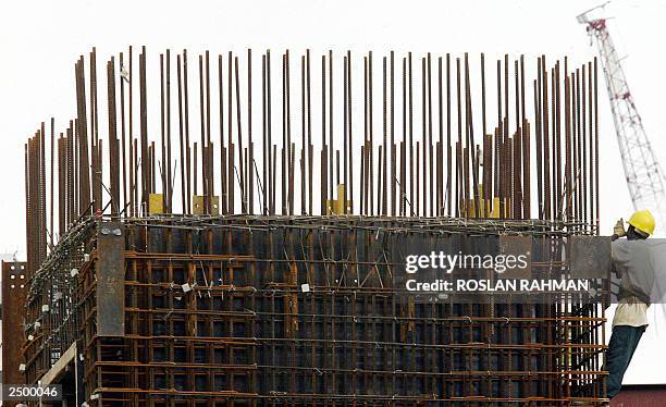 Worker holds onto a metal rod structure at a construction site in Singapore 29 August 2003. Singapore's gross domestic product is expected to rebound...