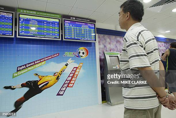 Man checks out soccer team results at a Hong Kong Jockey Club betting outlet in Hong Kong, 12 September 2003. Recent legislation introduced in...